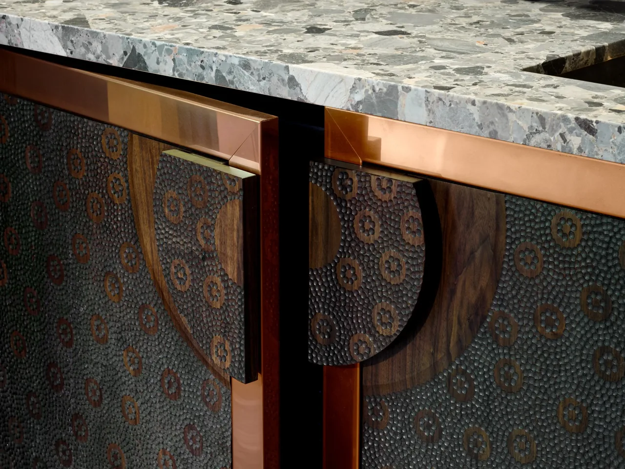 Textured copper cabinet panels on a kitchen island topped with stone in the Gallery House project.