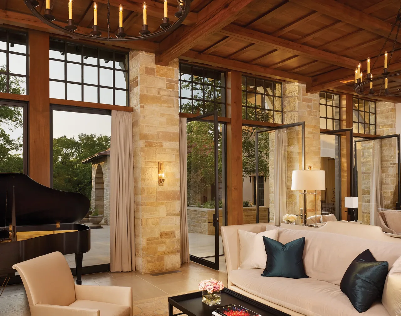 Turnberry by Michael G. Imber, Architects features large black-framed glass doors and stone columns in its living room.