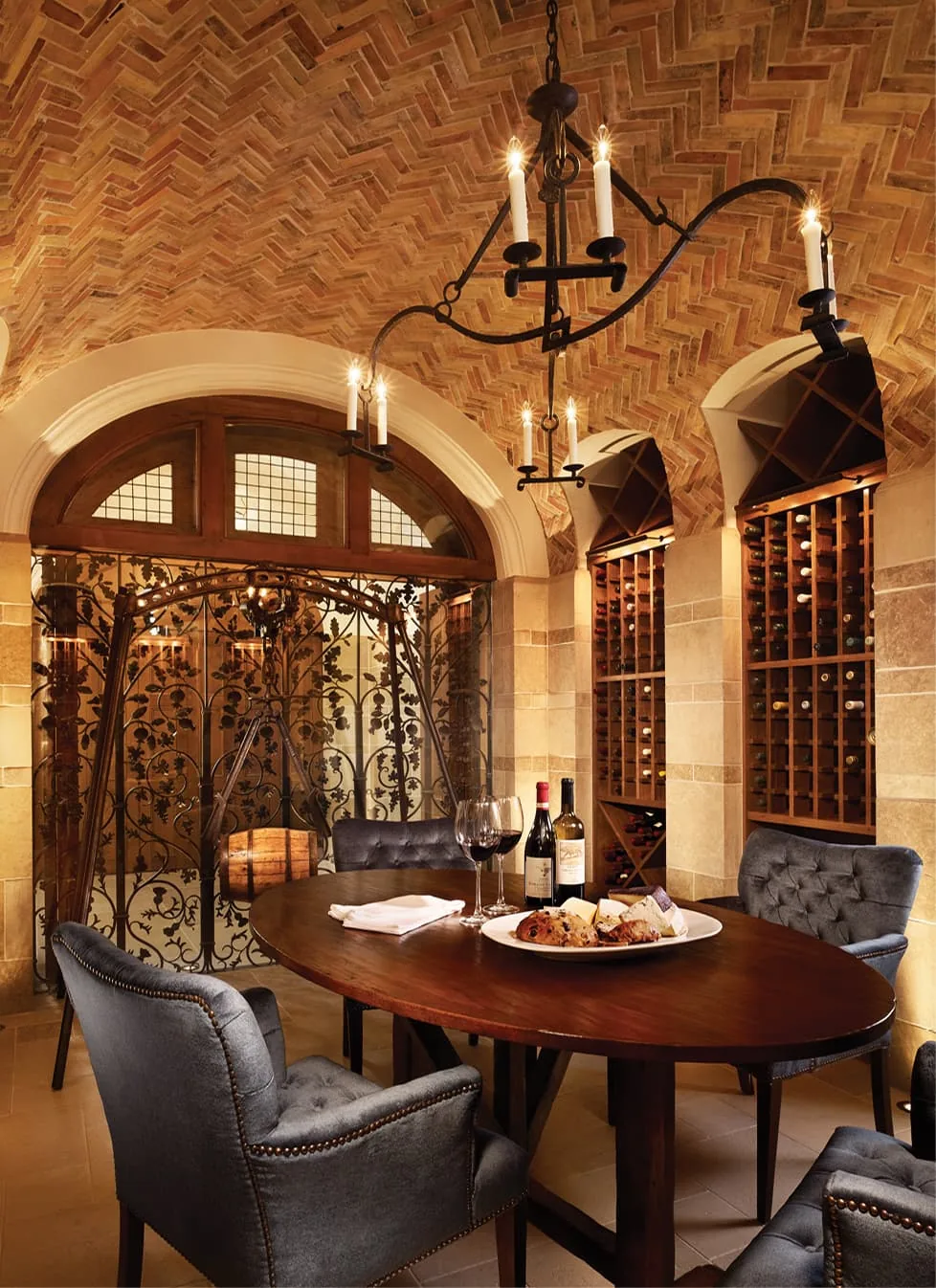 Turnberry wine tasting room features a brick vaulted ceiling, arched wine racks, and wrought iron chandelier with candle lights.