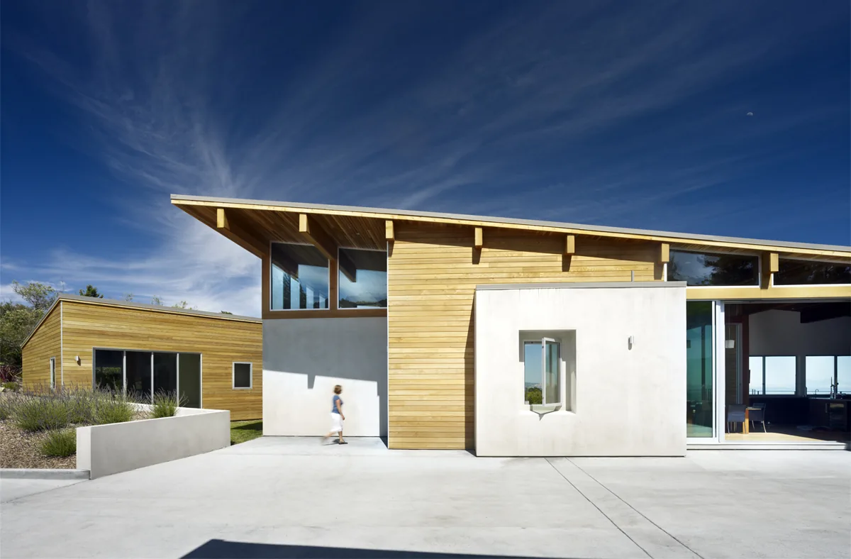 Modern home exterior with wood siding, stucco, and large windows at vistadelvalle project by Zimmerman + Associates.