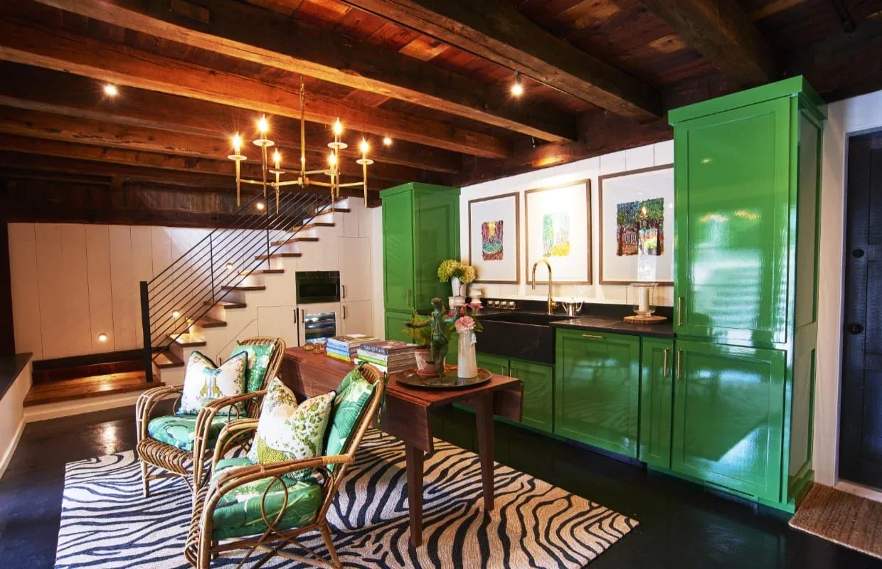 Kitchen interior with glossy green cabinets, a brass faucet, and a wooden beamed ceiling at Frog Pond Farm by Serge Young.