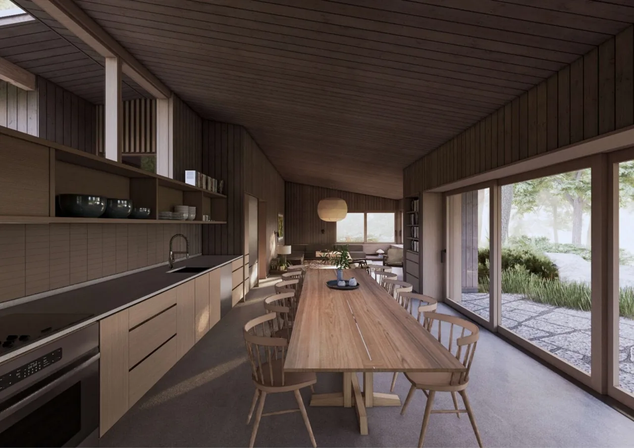 The Whidbey Bluff House kitchen and dining area features wood finishes and large sliding glass doors opening to an outdoor patio.