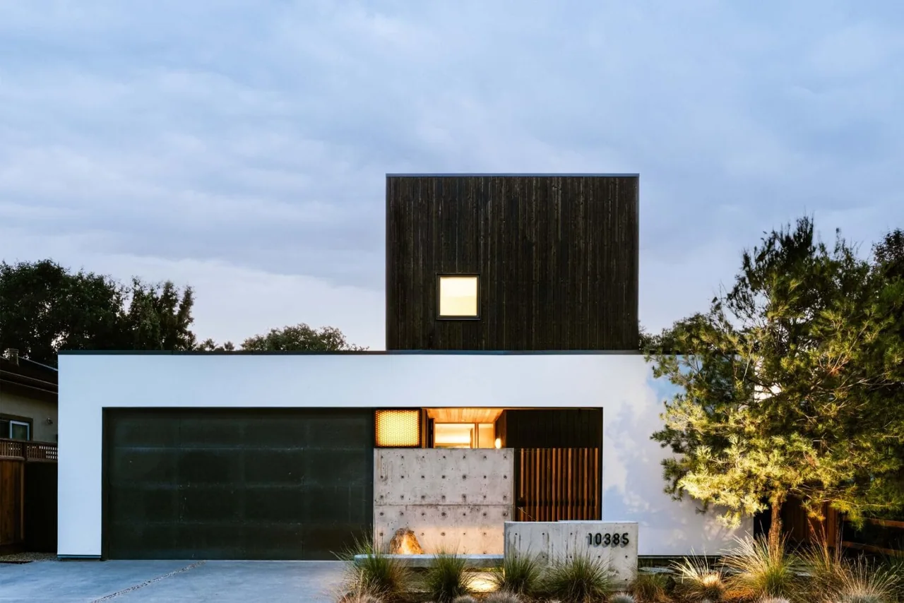 The Cupertino Courtyard House by SHED Architecture & Design features a boxy modern form with contrasting dark wood and white exterior walls.