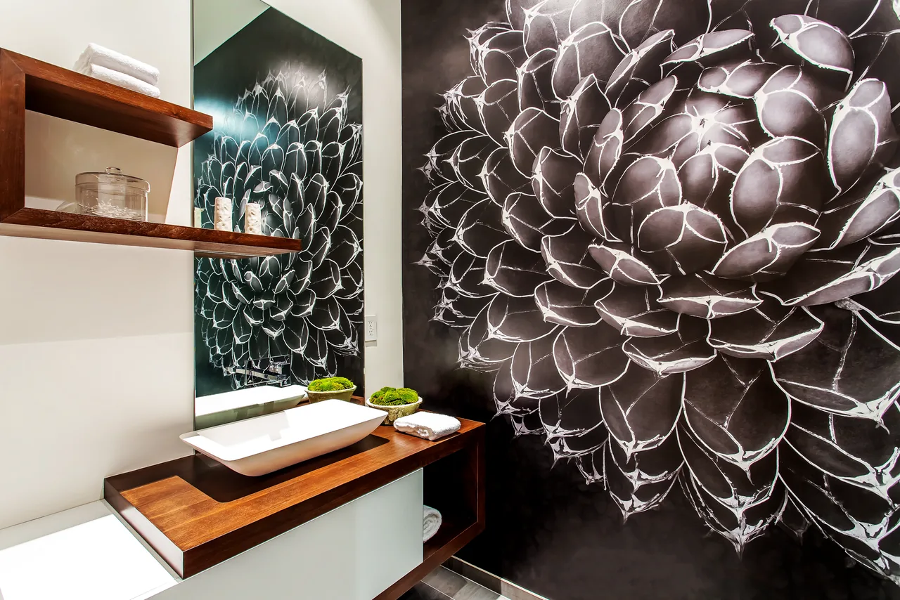 Bathroom features a large floral wall mural, floating wooden countertop sink, and wooden shelving for storage.