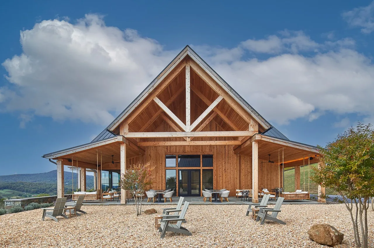 Crimson Lane Vineyard building features an A-frame gable roof and extensive covered patios with outdoor seating.