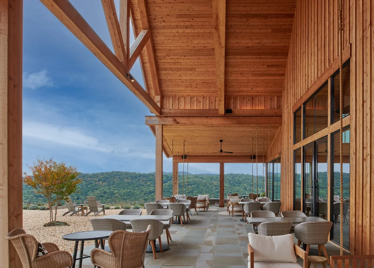 The outdoor living space at Crimson Lane Vineyard features a vaulted wooden ceiling with exposed beams and views of surrounding mountains.