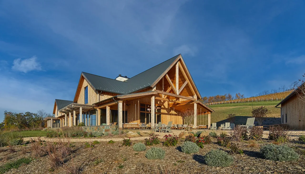 Exterior view of Crimson Lane Vineyard showing timber framing, triangular gable roof, and natural stone foundation.