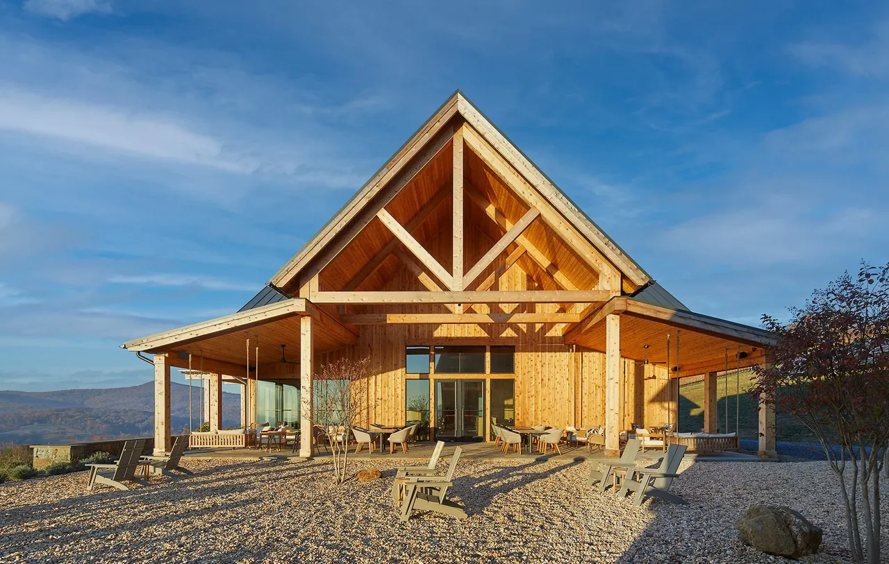 Crimson Lane Vineyard features exposed timber framing, a triangular gable, and natural stone gravel landscaping with a covered patio space.