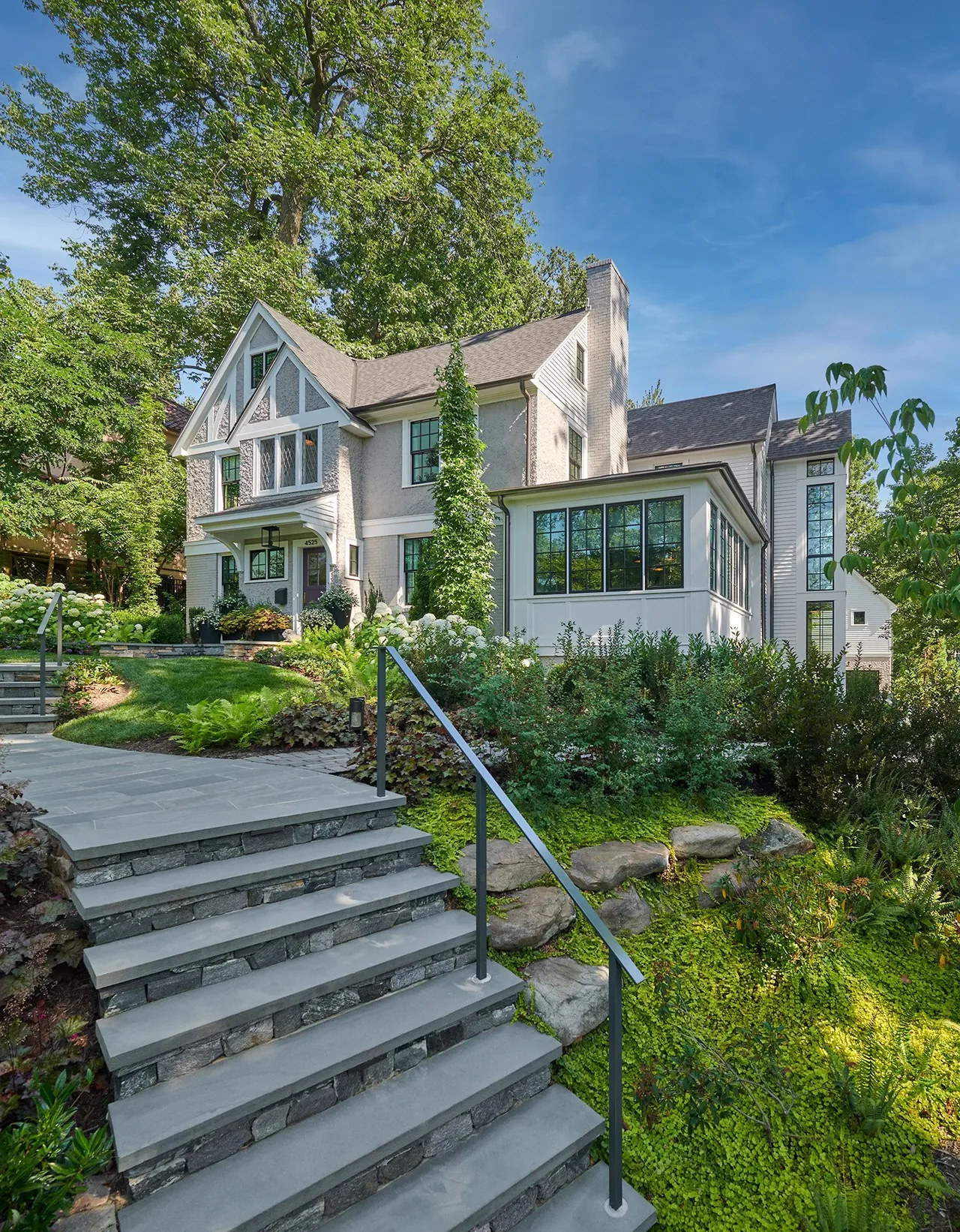 Traditional two-story home with multi-pane windows and landscaped entry steps.