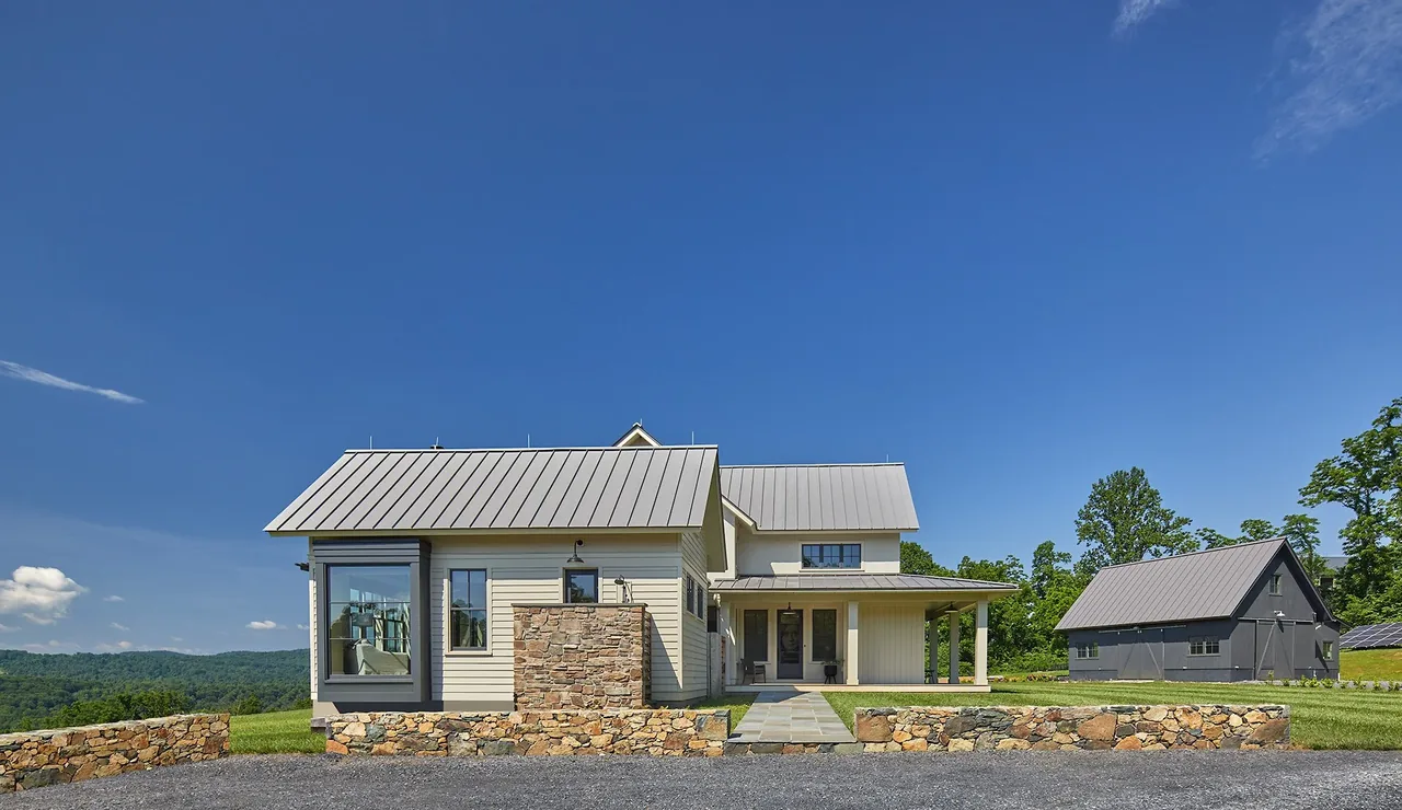 Crimson Lane Residence features white siding, metal roofing, and stone accents with a stone pathway and large lawn.