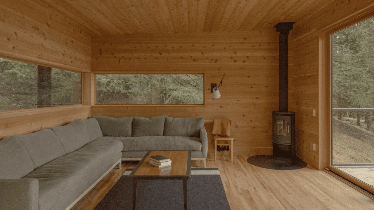 Interior of a wood-paneled living room featuring a sectional sofa, wood stove, and expansive windows with forest views.