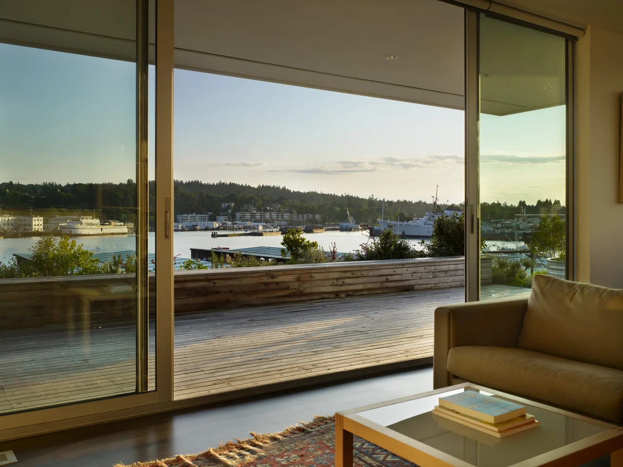 Living area at Sky Ranch with large sliding glass doors opening to a wooden deck and water views.
