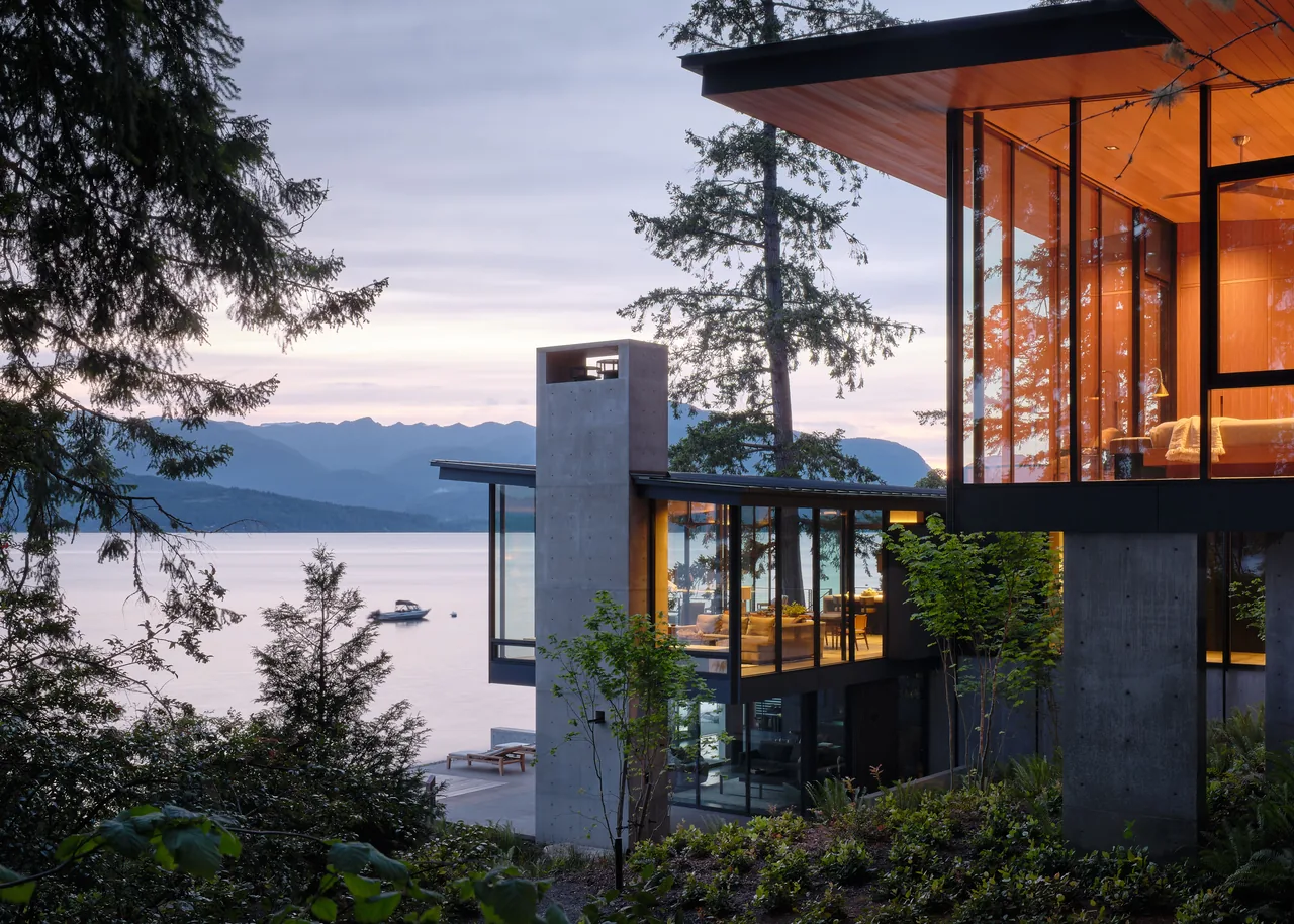 Surly Crab house featuring expansive floor-to-ceiling glazing and an exterior concrete chimney by Eerkes Architects.