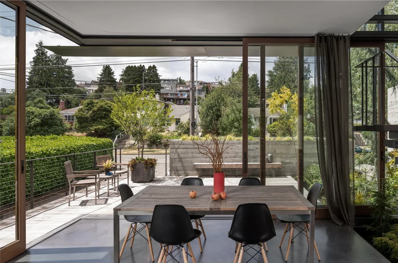 Indoor dining space opens to an outdoor deck with seating in the Magnolia residence.