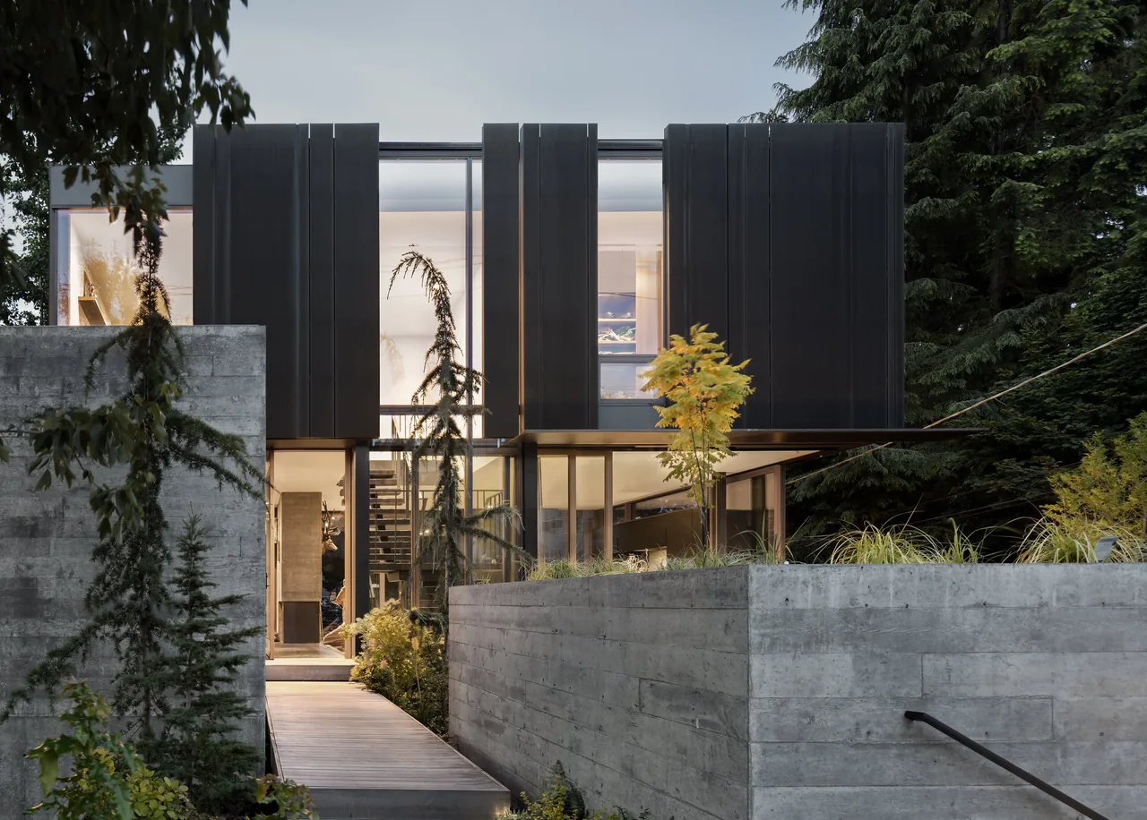 The Magnolia Residence features vertical black panels and floor-to-ceiling glazing with landscaped concrete planters.