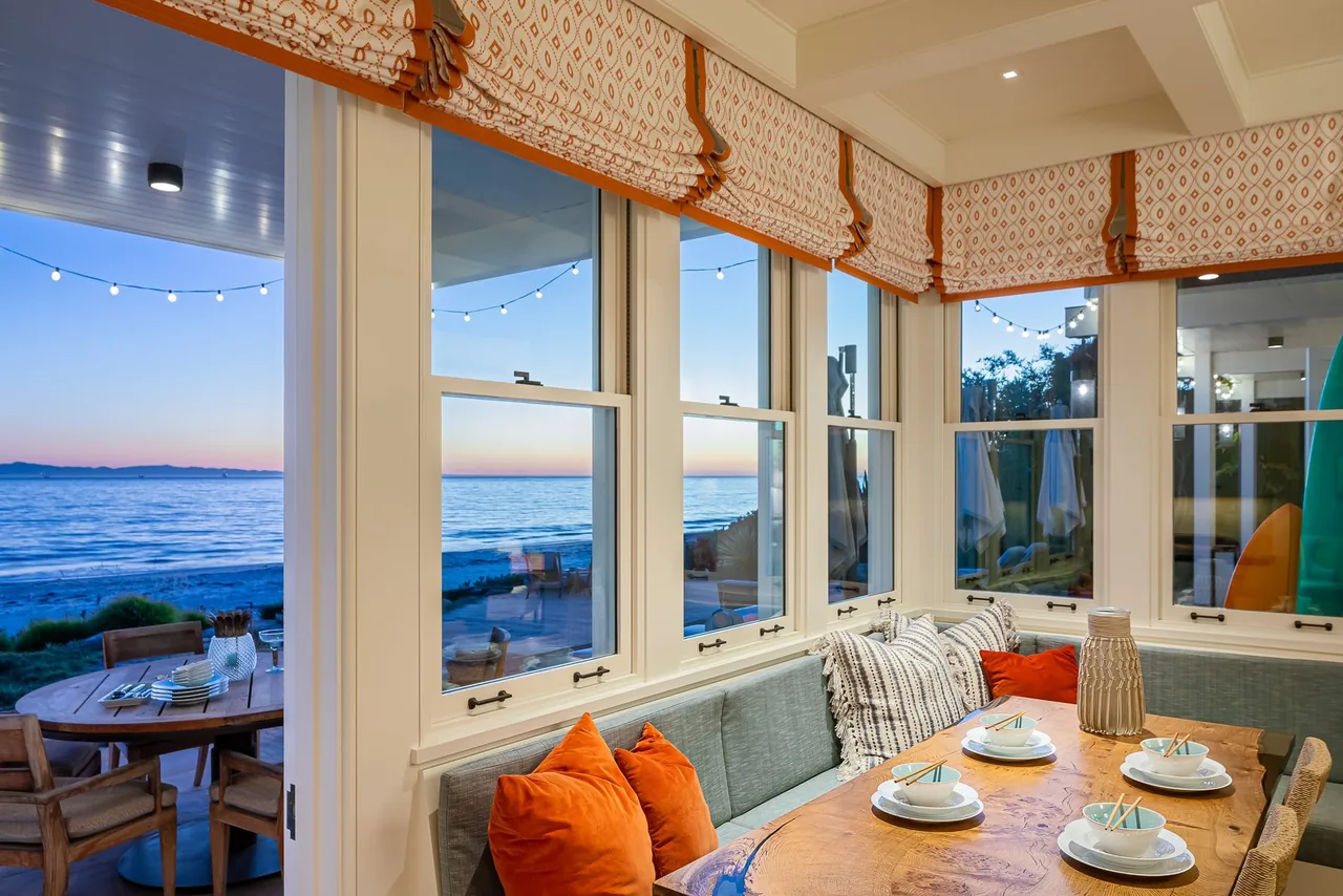 Dining nook in a beach home with built-in seating and ocean views at sunset.
