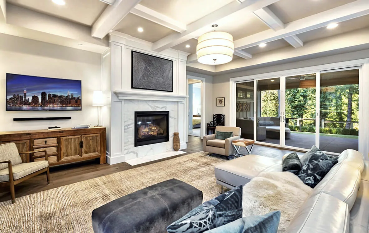 Living room featuring a white marble fireplace, white sectional sofa, and large sliding glass doors opening to an outdoor space.