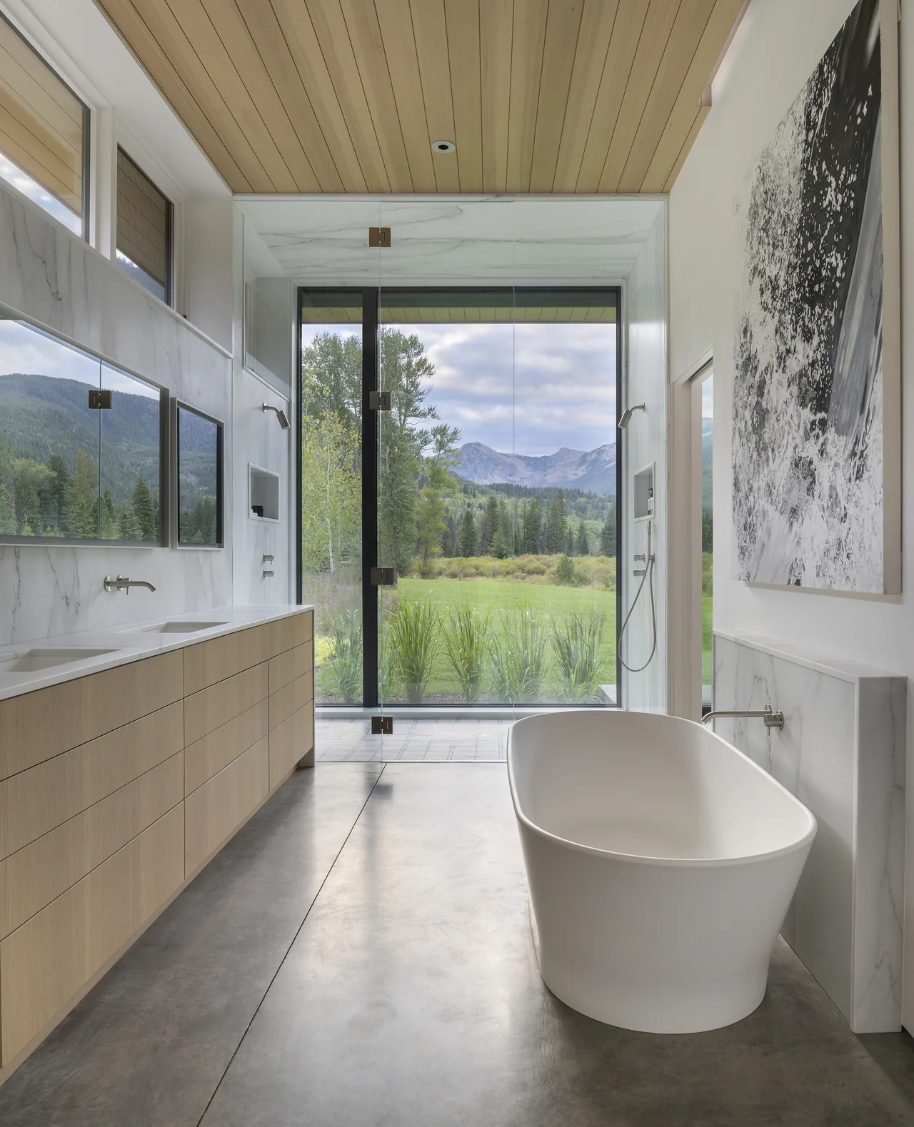 Bathroom features a freestanding tub, dual vanities, and a large glass window offering a mountain view.