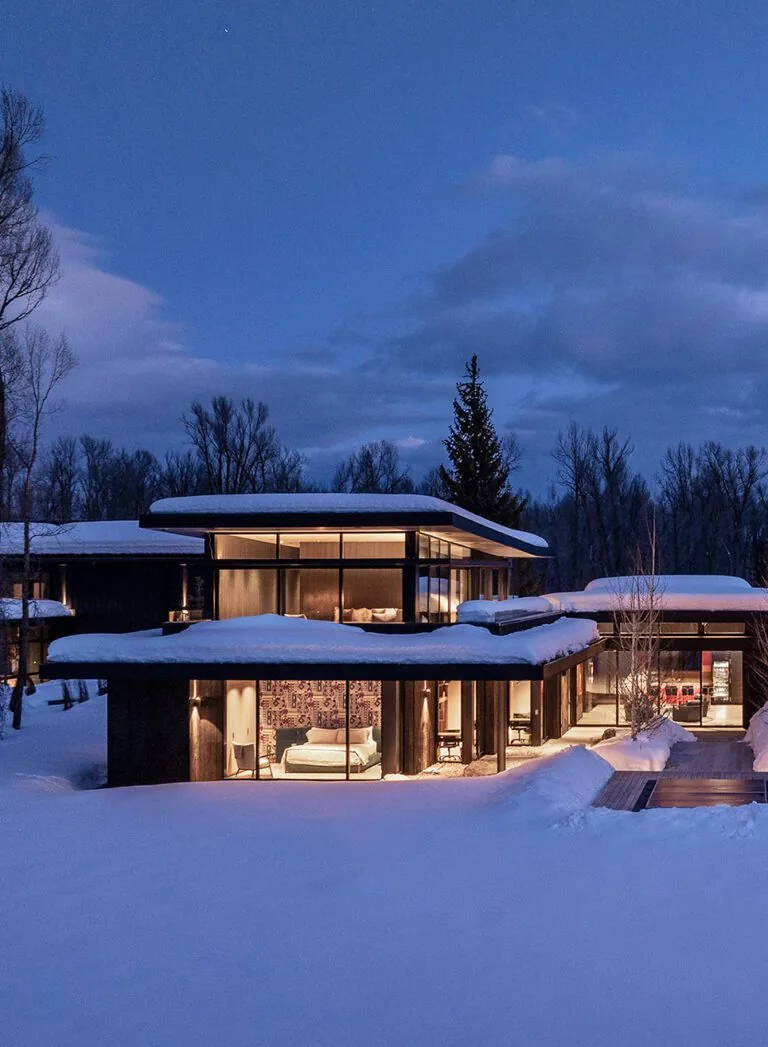 The Thunder Road house in Jackson Hole features flat roofs and floor-to-ceiling glazing with views of snowy landscape.
