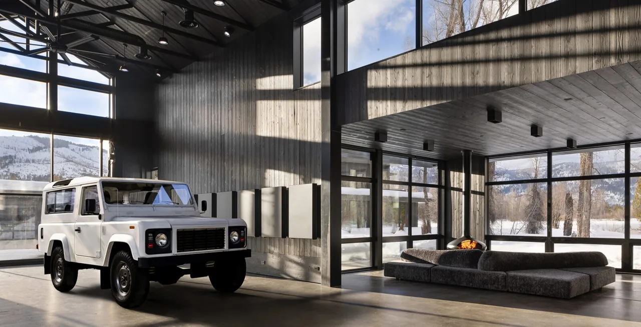 A modern living area features a vintage white SUV, floor-to-ceiling windows, and a corner fireplace with a sectional sofa.