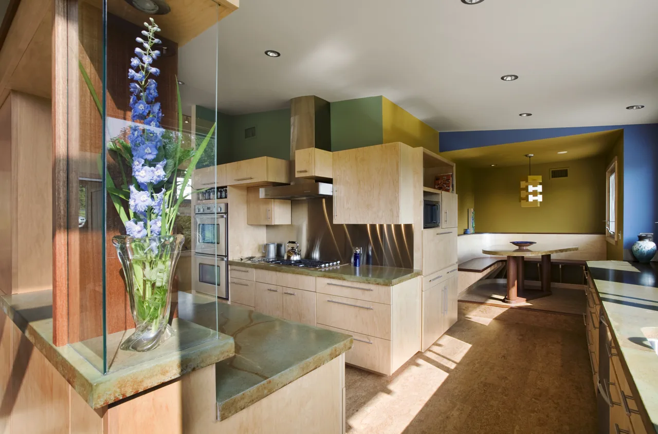 Kitchen featuring light wood cabinets, stainless steel appliances, and a cozy corner dining nook with a pendant light.