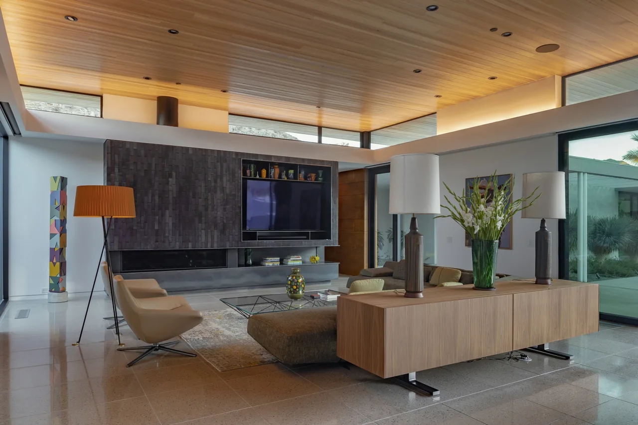 Living room in the Sky Ridge project, featuring a wood-paneled ceiling and large glass sliding doors to the outdoor area.