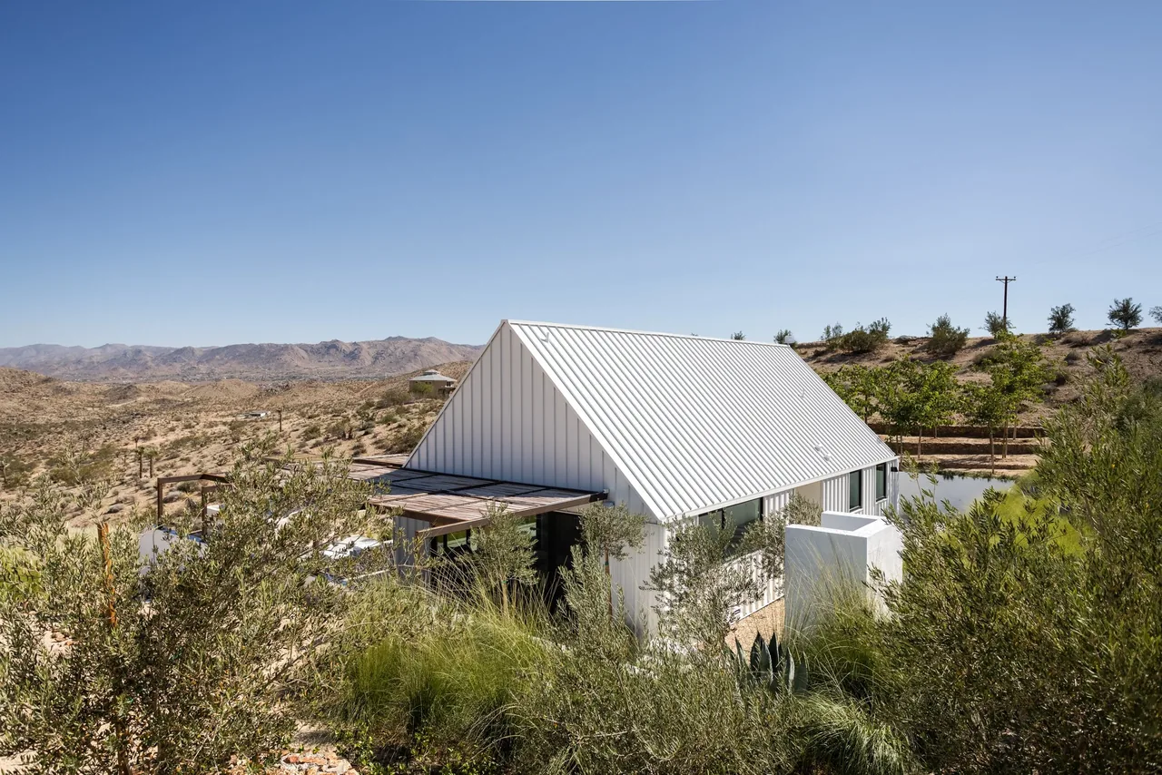 Alta guesthouse by Oller & Pejic features a white standing seam metal gable roof and vertical siding in a desert setting near Los Angeles.