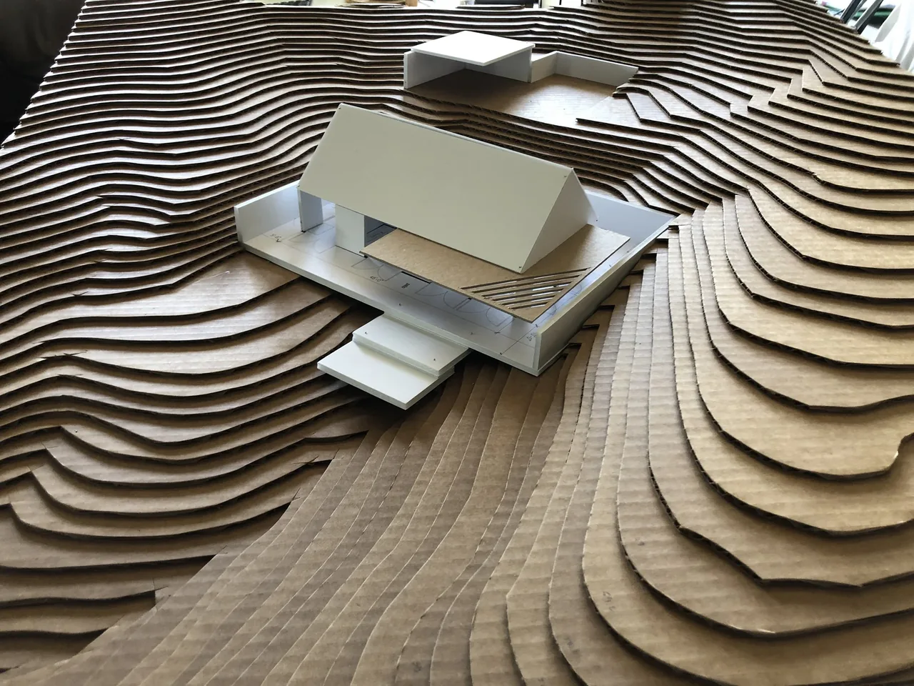 Physical model of Alta Guesthouse by Oller & Pejic, showing the house on layered terrain contours.