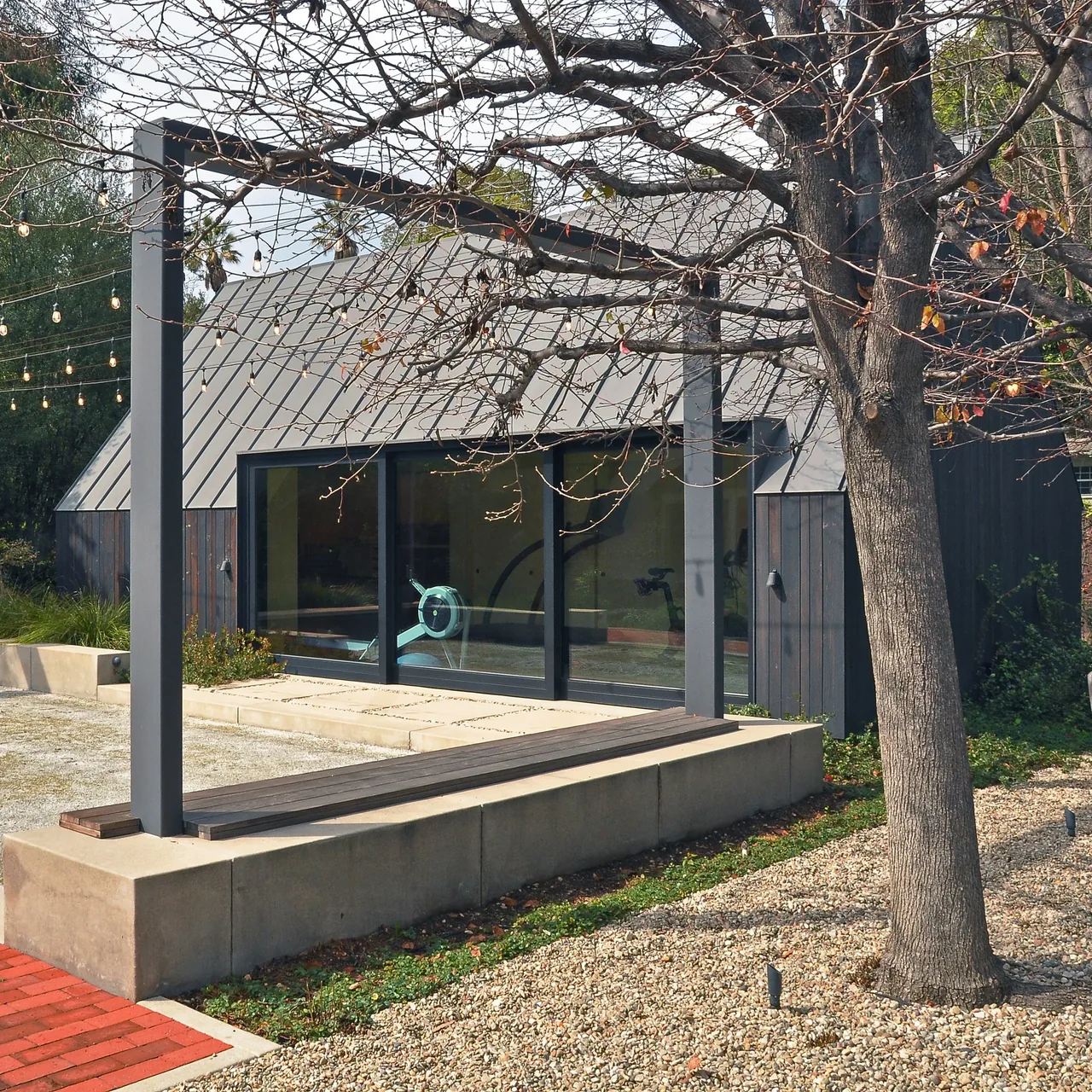Bellefontaine Studio with standing seam metal roof and large black-framed sliding glass doors.