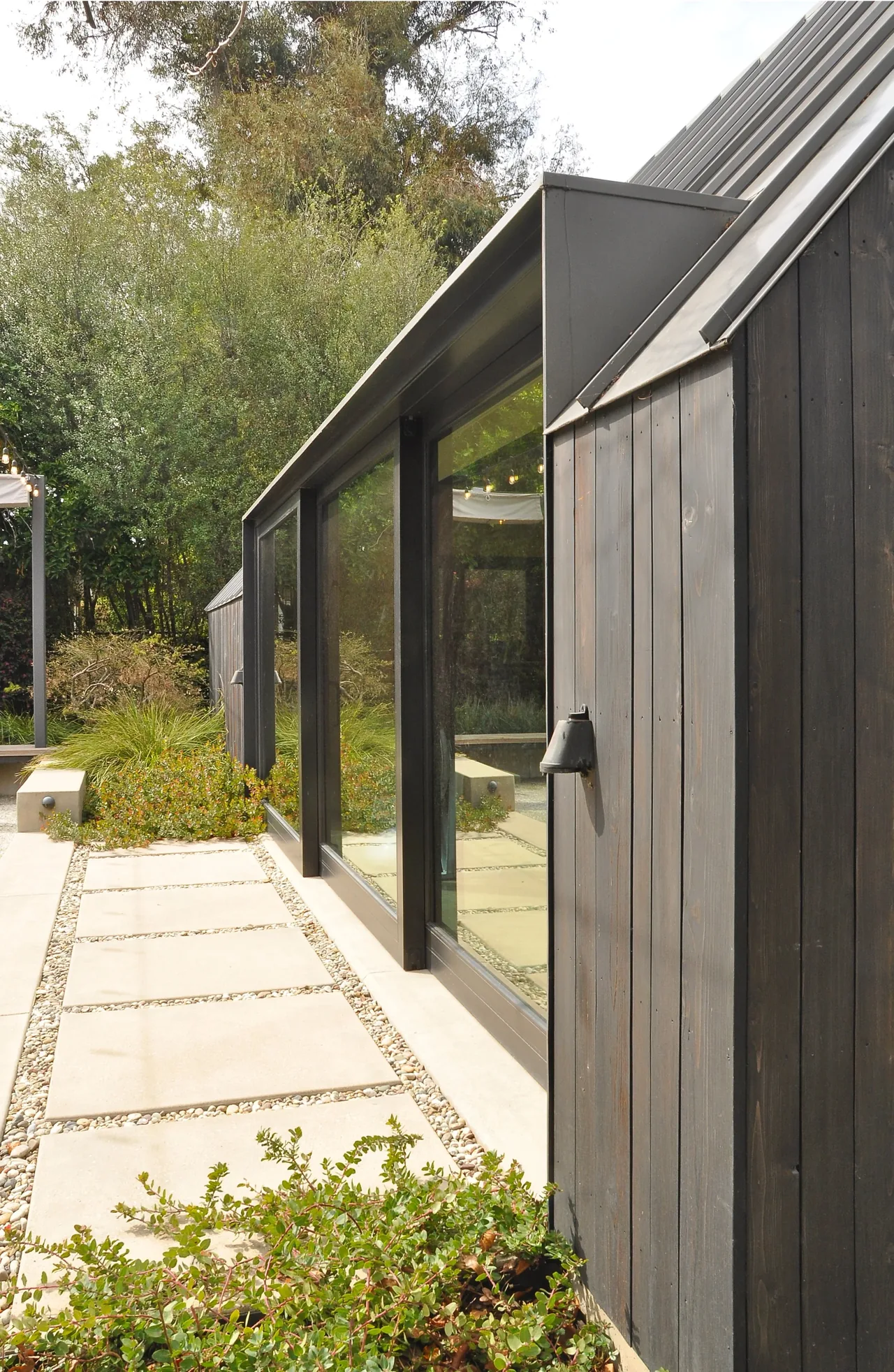 Bellefontaine Studio features large black window frames and vertical wood siding by Oller & Pejic.
