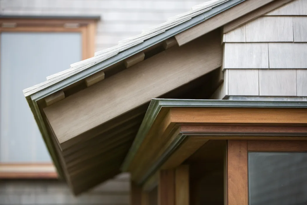 Exterior detail of wood-paneled overhang and shingle siding at the Vineyard Residence.