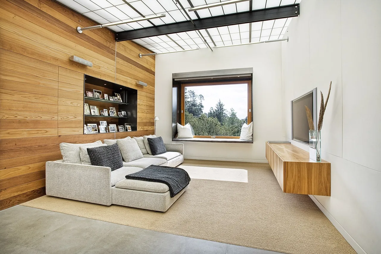 Living room of the Lovell Residence featuring wood wall paneling, a floating TV console, and a translucent ceiling.
