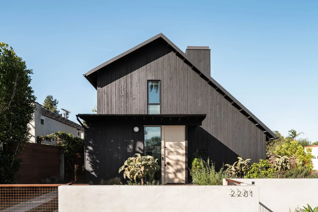 Glencoe Avenue House features a dark wood siding gable roof exterior with a vertical plank facade.