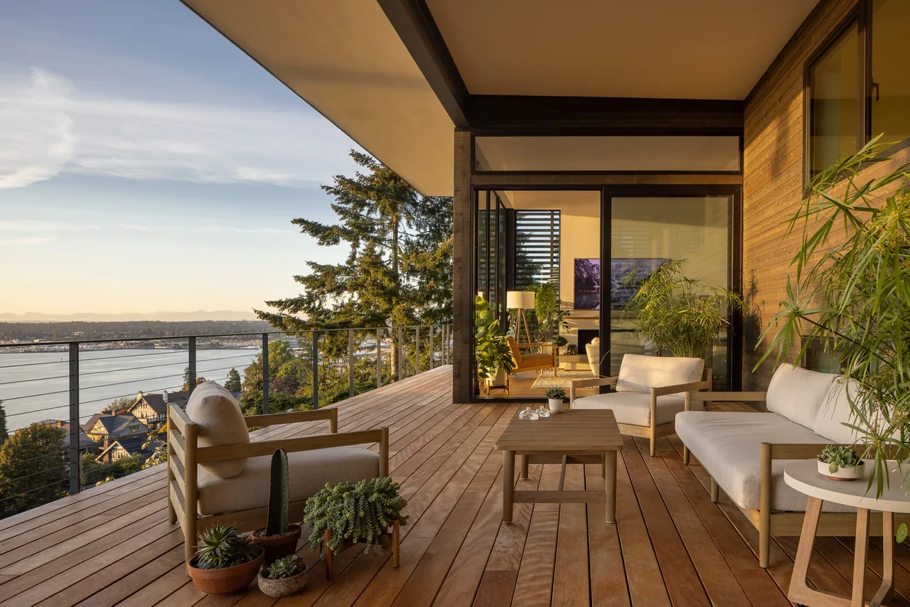 The Nest project features a wood deck with seating and cable railing overlooking a water view in Seattle.