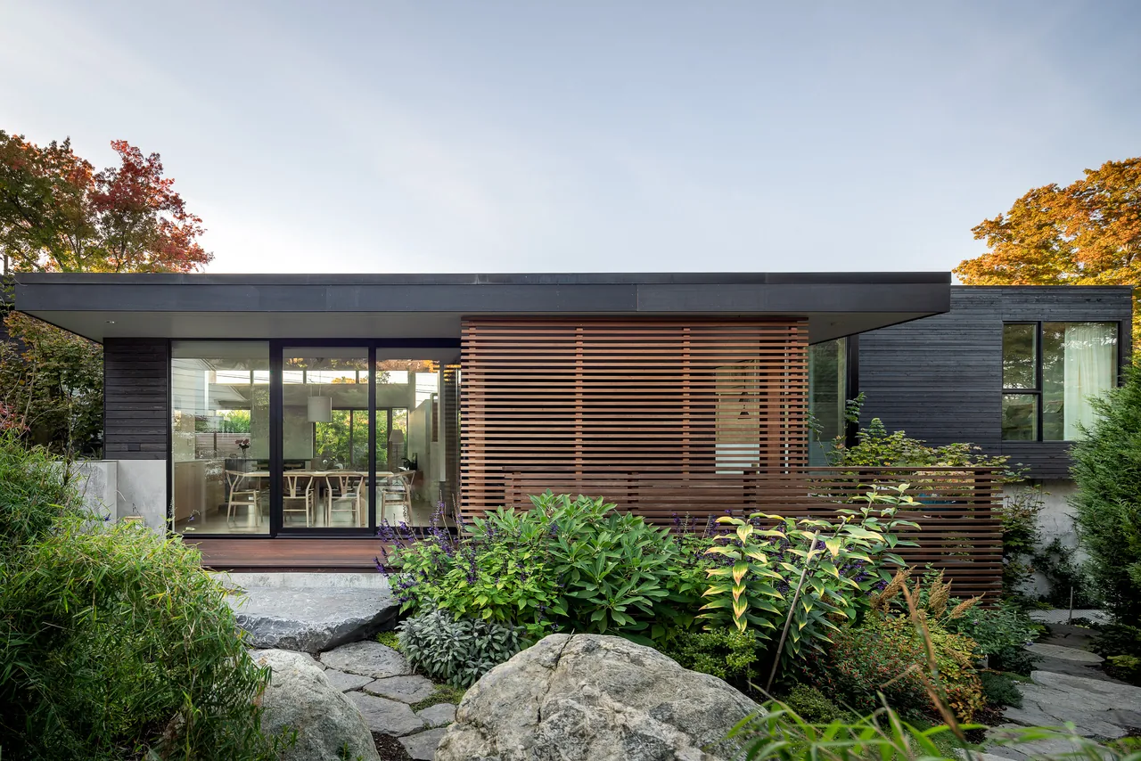 MADISON project by Replinger Hossner Architects, featuring a modern flat roof home with black window frames and a wooden privacy screen.