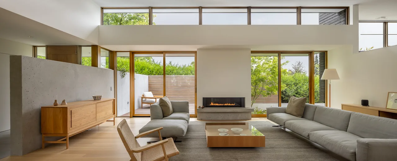Spacious living room in the MADISON project features natural light from clerestory windows and a linear fireplace.