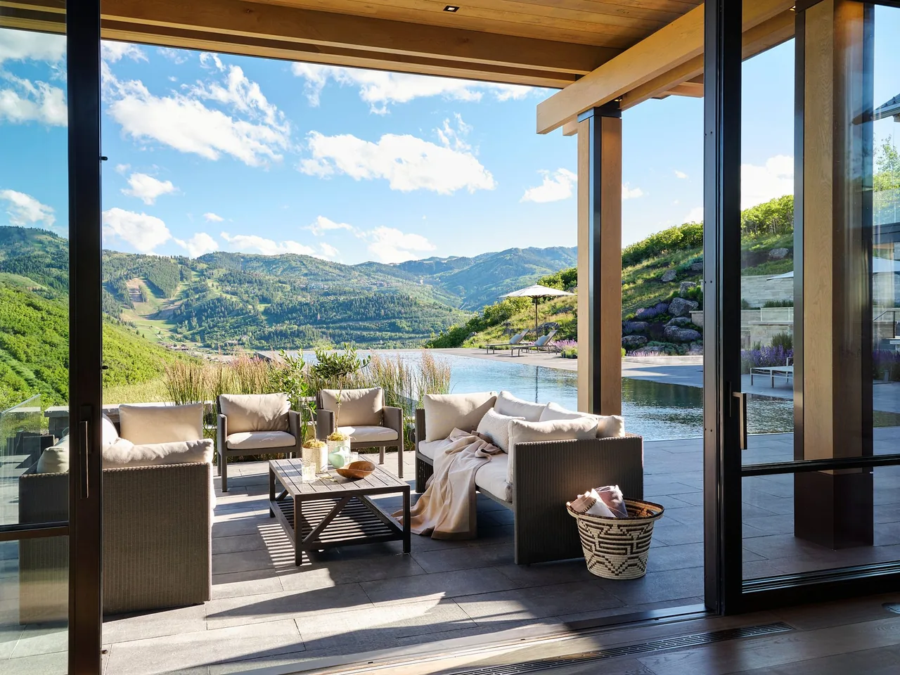 The Morning Star Residence features an outdoor living area with lounge furniture beside a rectangular infinity pool and mountain views.