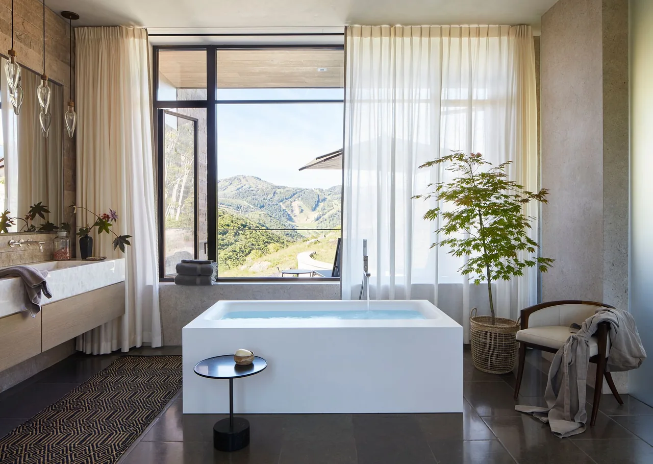 The Morning Star Residence bathroom features a freestanding tub with mountain views through floor-to-ceiling glazing.