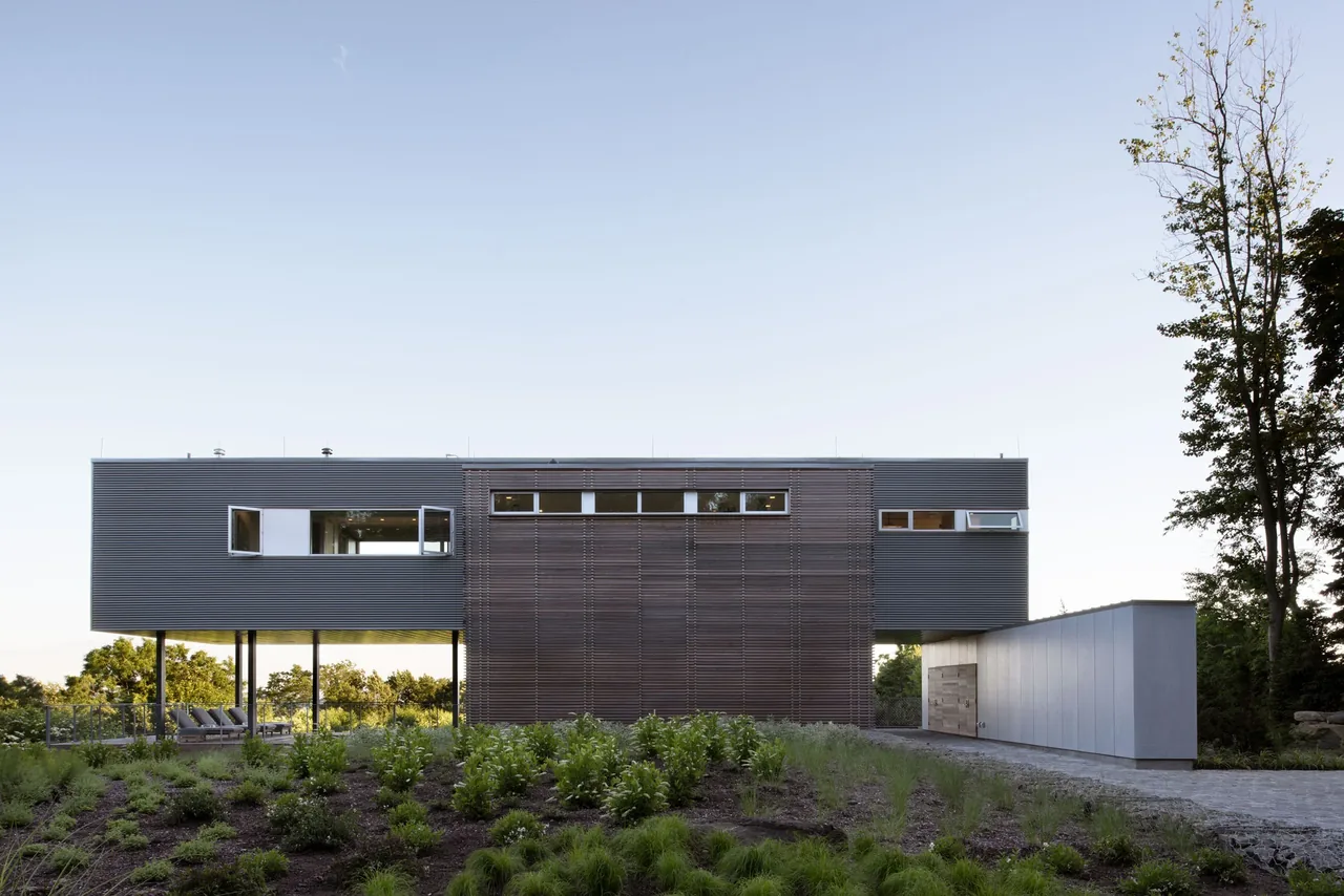 Exterior front view of the Hudson River House featuring elevated modern design and mixed material facade.