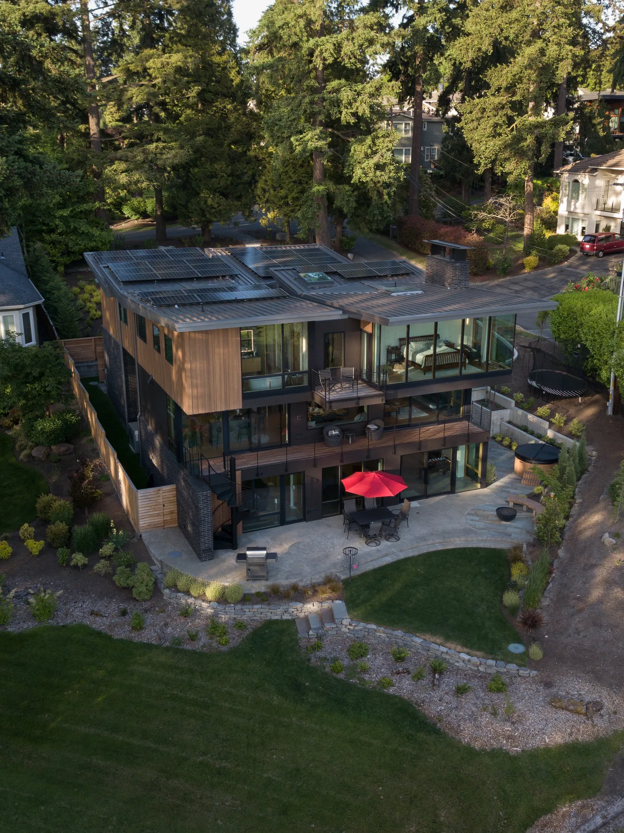 Wingspan Residence features overhanging flat metal roofs with solar panels and an outdoor stair with metal railing.