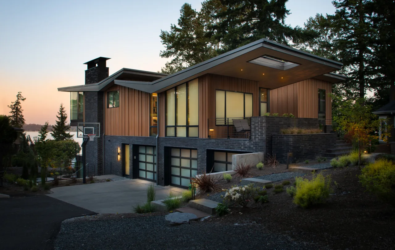 Wingspan Residence features an overhanging flat roof and a blend of brick and wood exterior siding in Seattle.