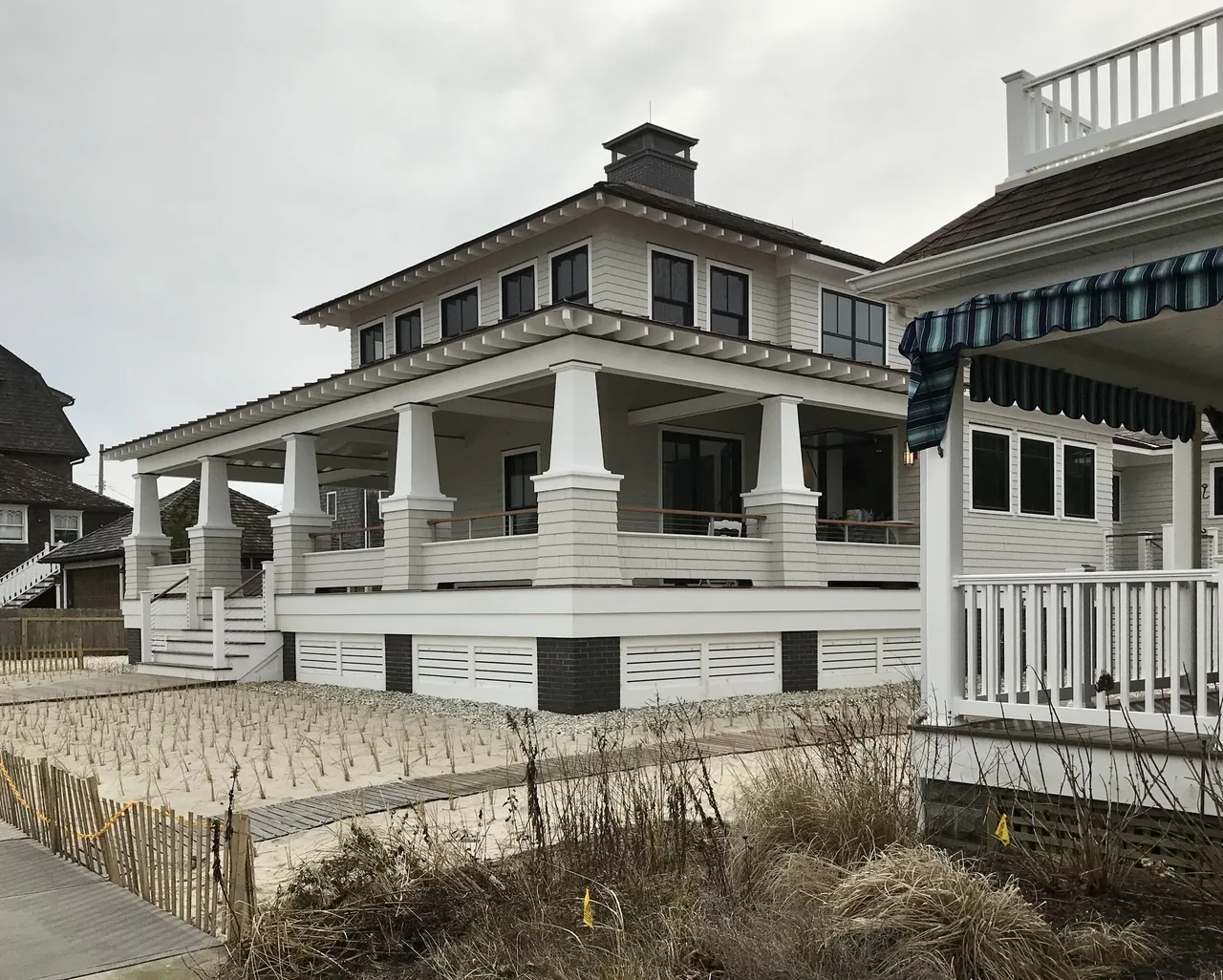 Porch Talk House with wrap-around porch and tapered columns in Seaside Park, designed by Richard Bubnowski Design.