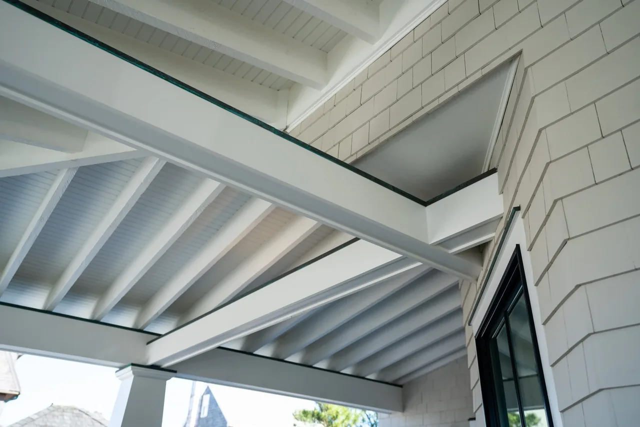 Porch ceiling with exposed white beams and shingle siding at Porch Talk House, Seaside Park.