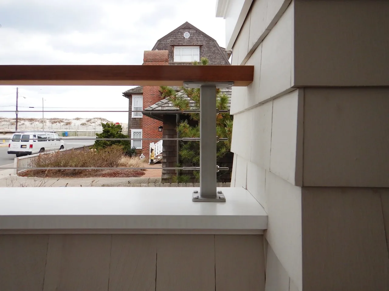 Cable railing detail on a porch with a view to a nearby house and road in Seaside Park.