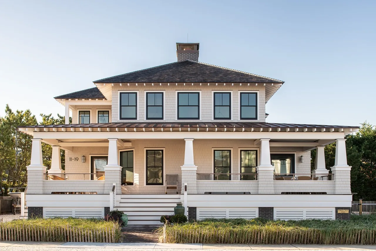 Porch Talk House by Richard Bubnowski Design features a symmetrical facade with a large covered porch and hip roof.