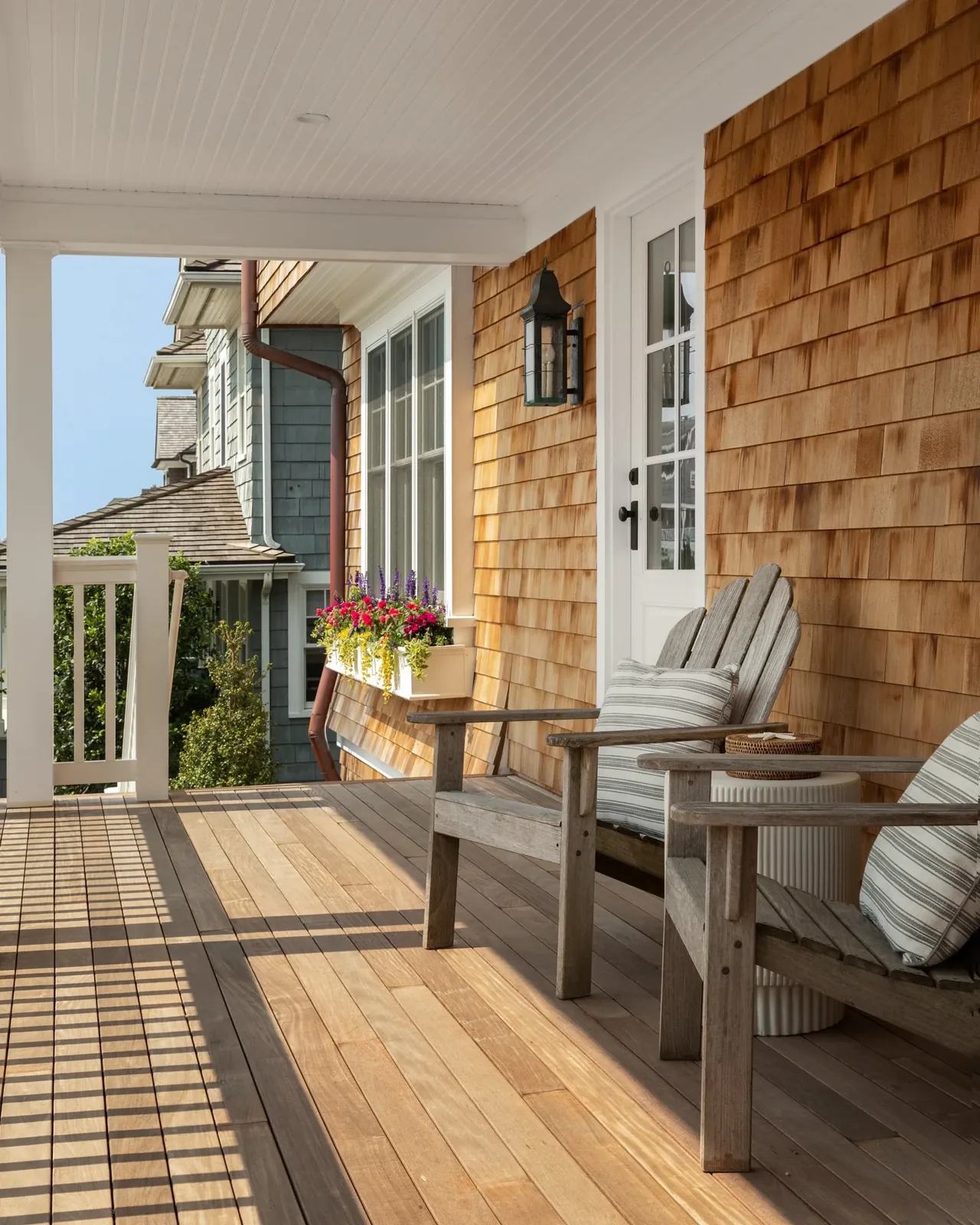 The Hagerstrom residence porch features wood siding, a flower box, and comfortable seating in New York.