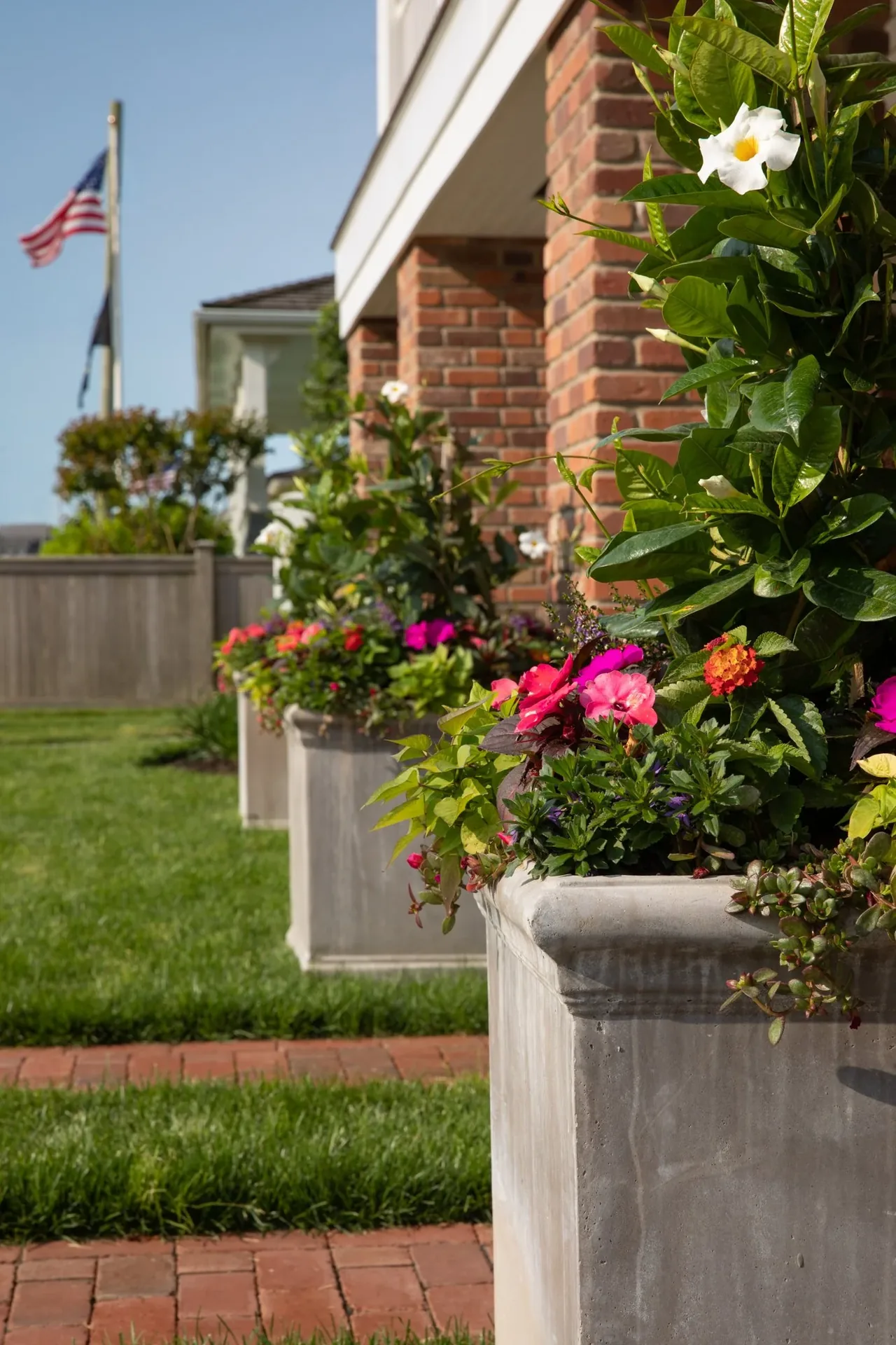 Flower boxes with vibrant plants line the exterior brick wall of the raised Hagerstrom residence.