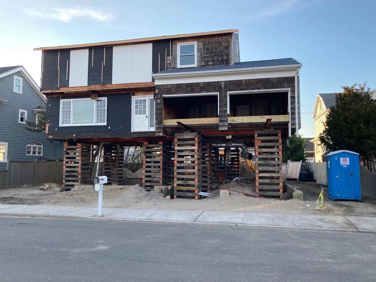 Hagerstrom residence elevated on wooden beams, showing structural work and unfinished exterior sections.