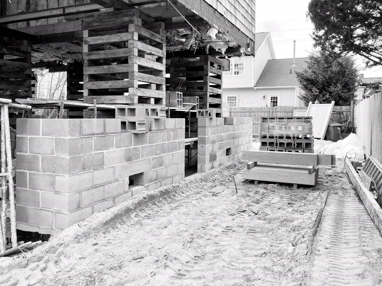Early construction phase of the Hagerstrom residence with concrete block foundation and wooden shoring visible.