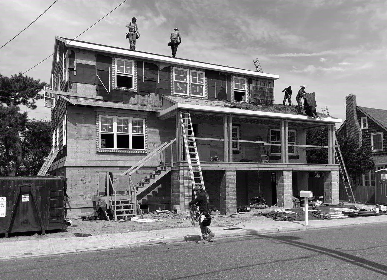 Hagerstrom residence under construction with raised porch and double garage openings visible.